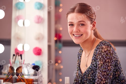 Preview: Portrait Of Teenage Girl Wearing Orthodontic Braces Sitting At Make Up Mirror In Bedroom At Home