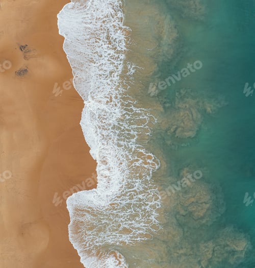 Preview: Aerial shot of the foamy waves of the ocean meeting the sands on the beach