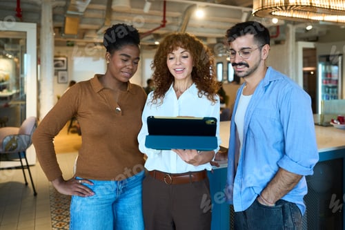 Preview: Diverse business team collaborating using digital tablet