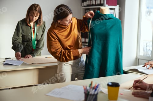 Preview: Measuring of dress length by a female fashion designer