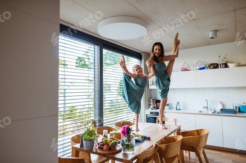Preview: Little girl and mother dancing on the kitchen table as ballerinas.