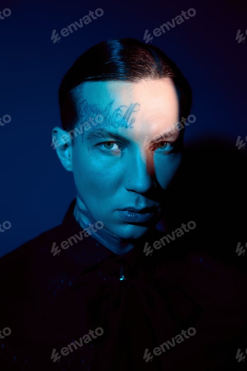 Preview: Handsome young man showcases bold fashion choice against a striking deep blue backdrop