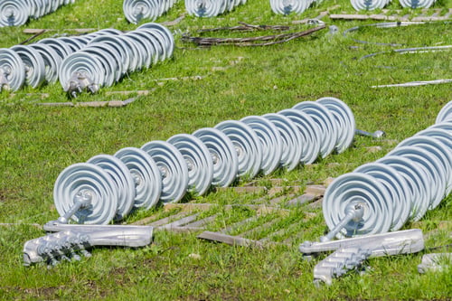 Preview: Ceramic insulators spread on a green meadow waiting to replace old ones, California