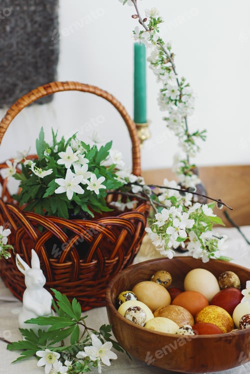 Preview: Easter eggs in wooden bowl on rustic table with bunny, basket and spring flowers. Happy Easter!
