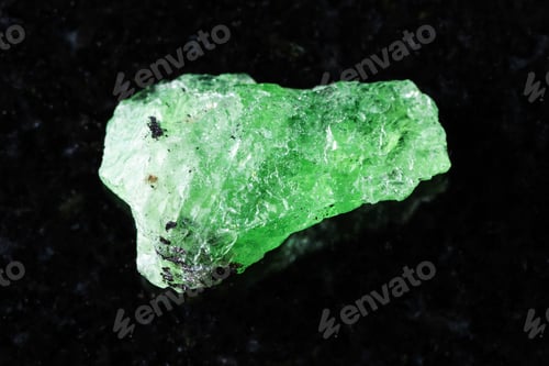 Preview: sample of raw tsavorite garnet mineral on black