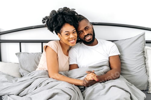 Preview: Photo of a satisfied positive spouses, African American man and woman, dressed in home clothes