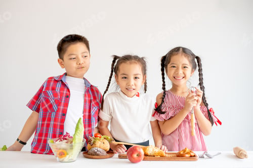 Preview: Group of little Asian girls and boy express happy and fun emotion with various food on table