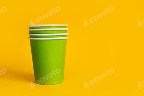 Preview: Green paper cups stack on yellow background