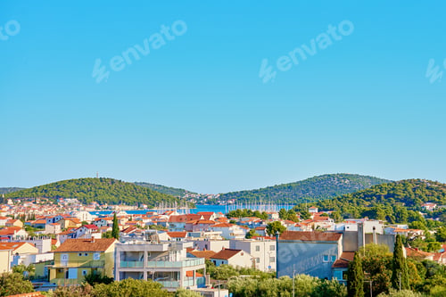 Preview: Scenic View of Coastal Town with Red Roofs near Hills
