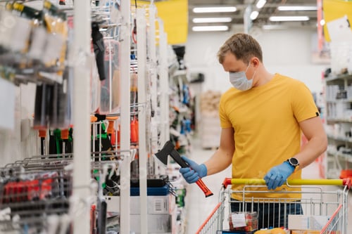 Preview: Man wears medical protective mask and gloves, prevents from coronavirus, poses with shopping cart