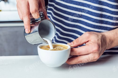 Preview: partial close up view of man pouring milk into coffee