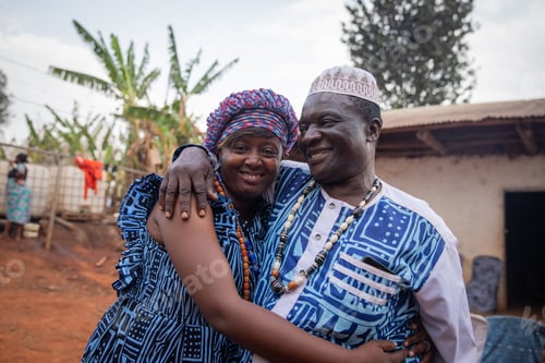 Preview: Two African people wearing traditional clothes hug each other during a celebration at the village.