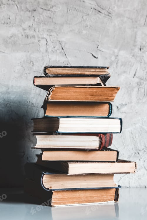 Preview: Education and reading concept, group of old colorful books on the white table on the gray background