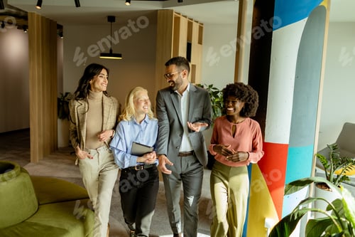 Preview: Collaborative team walks through the modern office space, sharing ideas and laughter