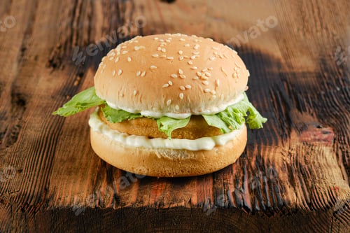 Preview: Chicken burger with fresh iceberg lettuce on wooden board