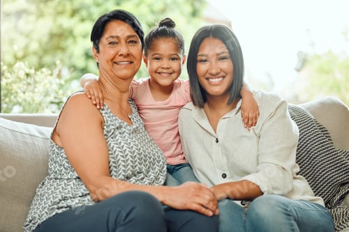 Preview: Portrait of a mature woman bonding with her daughter and granddaughter on the sofa at home