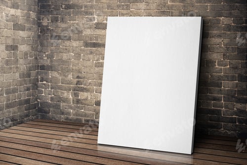 Preview: Blank white canvas frame leaning at grunge brick wall and wood floor