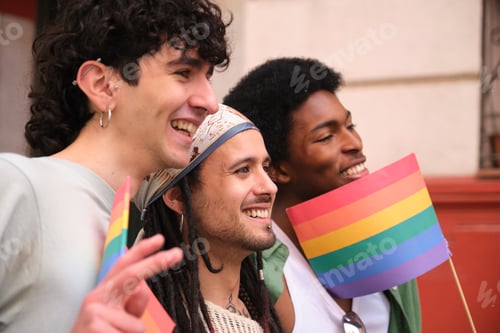 Preview: Group of friends showing rainbow flags at pride parade celebrating lgbtq plus community