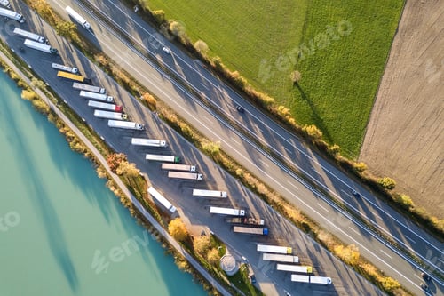 Preview: Top down aerial view of highway interstate road with fast moving traffic and parking lot with parked