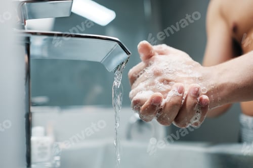 Preview: Man Washing Hands With Water And Soap In Bathroom