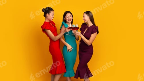 Preview: Three Models Clinking Glasses With Red Wine Over Yellow Background
