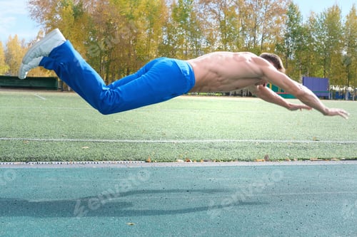 Preview: middle aged man doing jumping push-ups on a stadium.