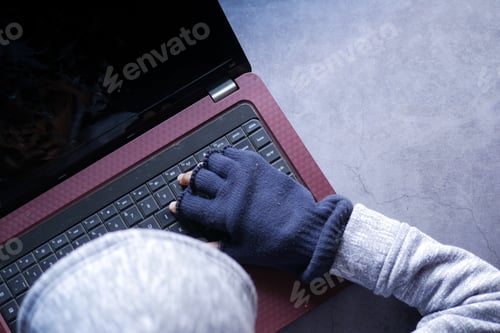 Preview: hacker hand stealing data from laptop top down