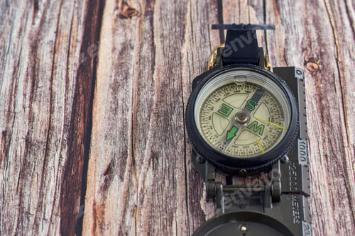 Preview: Top view closeup of an opened compass placed on a wooden table