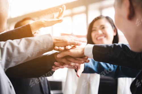 Preview: Large business team showing unity with their hands together, business success concept