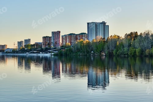 Preview: Residential buildings and embankment of town Krasnokamsk, Russia. View from Kama River at sunset