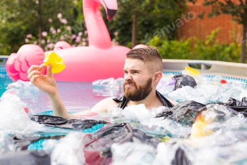 Preview: Ecology, plastic trash, environmental emergency and water pollution - shocked man swim in a dirty