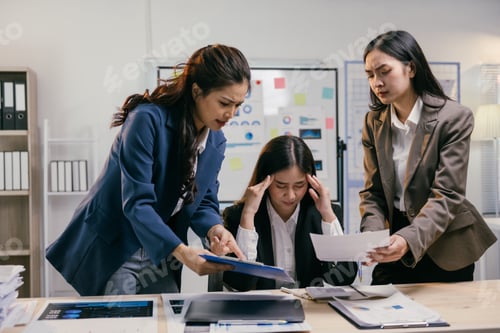 Preview: Stressed asian businesswomen having dispute over paperwork showing bad results, pointing at charts a