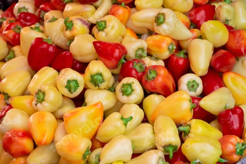 Preview: Red and yellow sweet peppers on counter in market