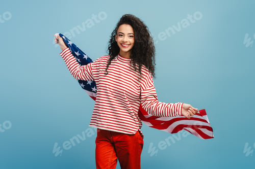 Preview: Portrait of happy, smiling girl, teenager holding in American flag, rejoicing in victory