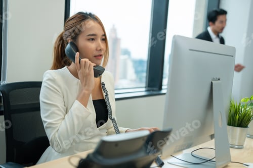 Preview: Friendly smiling woman call center operator with headset using computer.