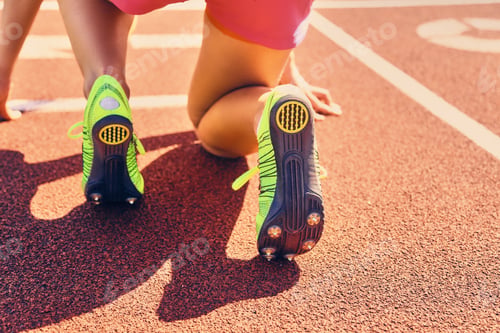 Preview: Blond sporty female runner to quick start position.