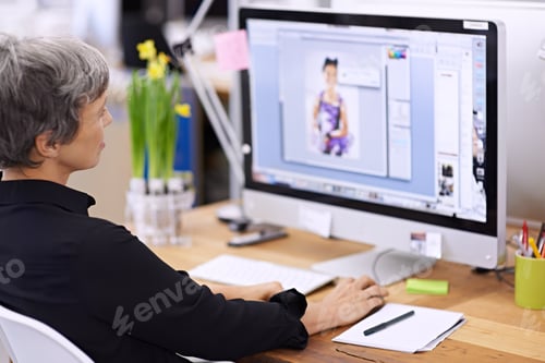 Preview: Perfection is her goal. Shot of a mature female designer working on a desktop computer.