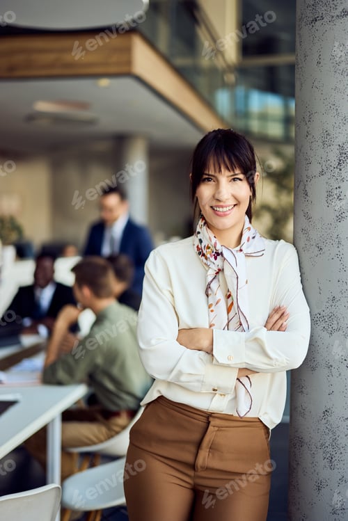 Preview: Confident Professional Woman Smiling While Leaning Against a Column in Modern Office