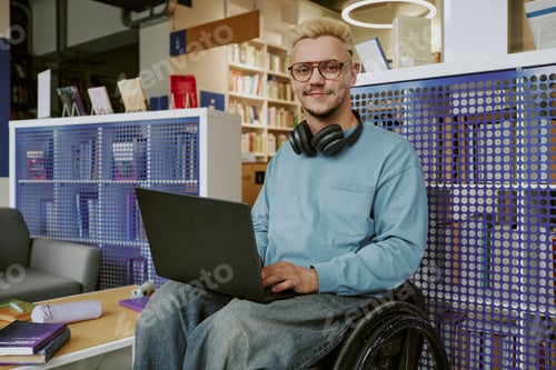 Preview: Portrait of Smiling Young Man Using Laptop in Wheelchair