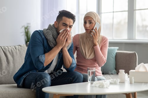 Preview: Woman in hijab calling ambulance, sitting by sick husband