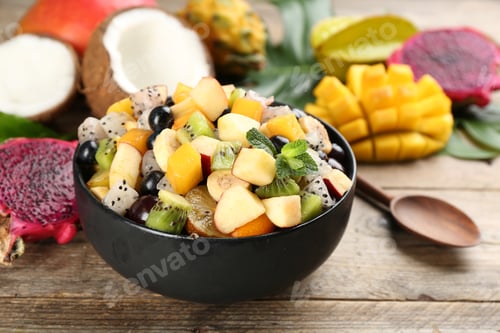 Preview: Delicious exotic fruit salad and ingredients on wooden table