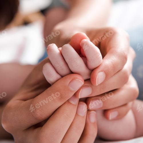 Preview: close up of mother holding hand infant daughter