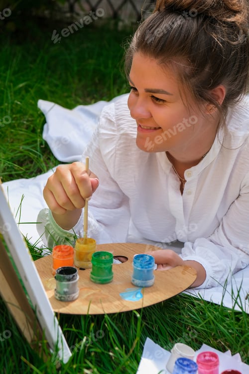 Preview: Artist painting on the easel outdoors in the garden. Open air outdoor art workshop. Draw on the canv