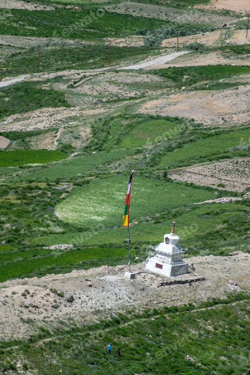 Preview: Scenic view of a hill with a grassy field, lush green grass and a flag fluttering atop it