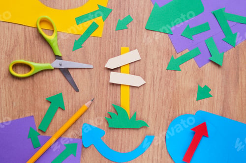 Preview: Scissors and different paper figures on wooden table, flat lay. Space for text