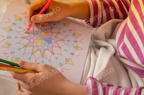 Preview: Woman coloring antistress page. Female hand painting mandala. Female painting mandalas to combat str