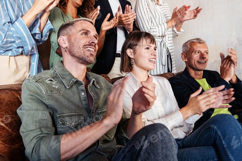 Preview: A group in casual clothing made up of people of different ethnicities and ages applaud during a spee