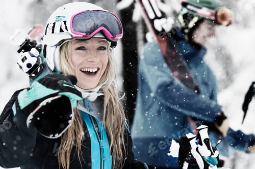 Preview: Mid adult woman holding skis, laughing