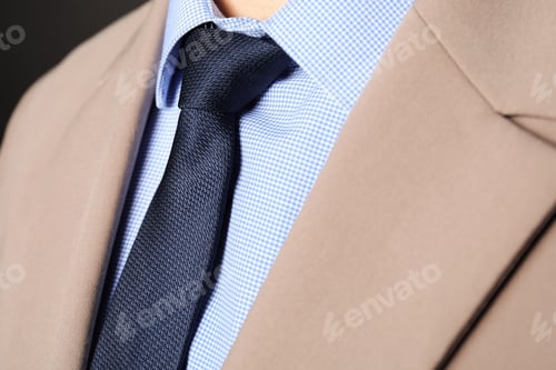 Preview: Man in suit with stylish necktie on black background, closeup