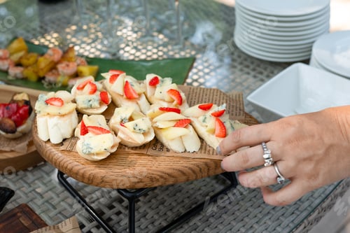 Preview: Rustic wooden plate of appetizers with strawberries, cheese, and bread